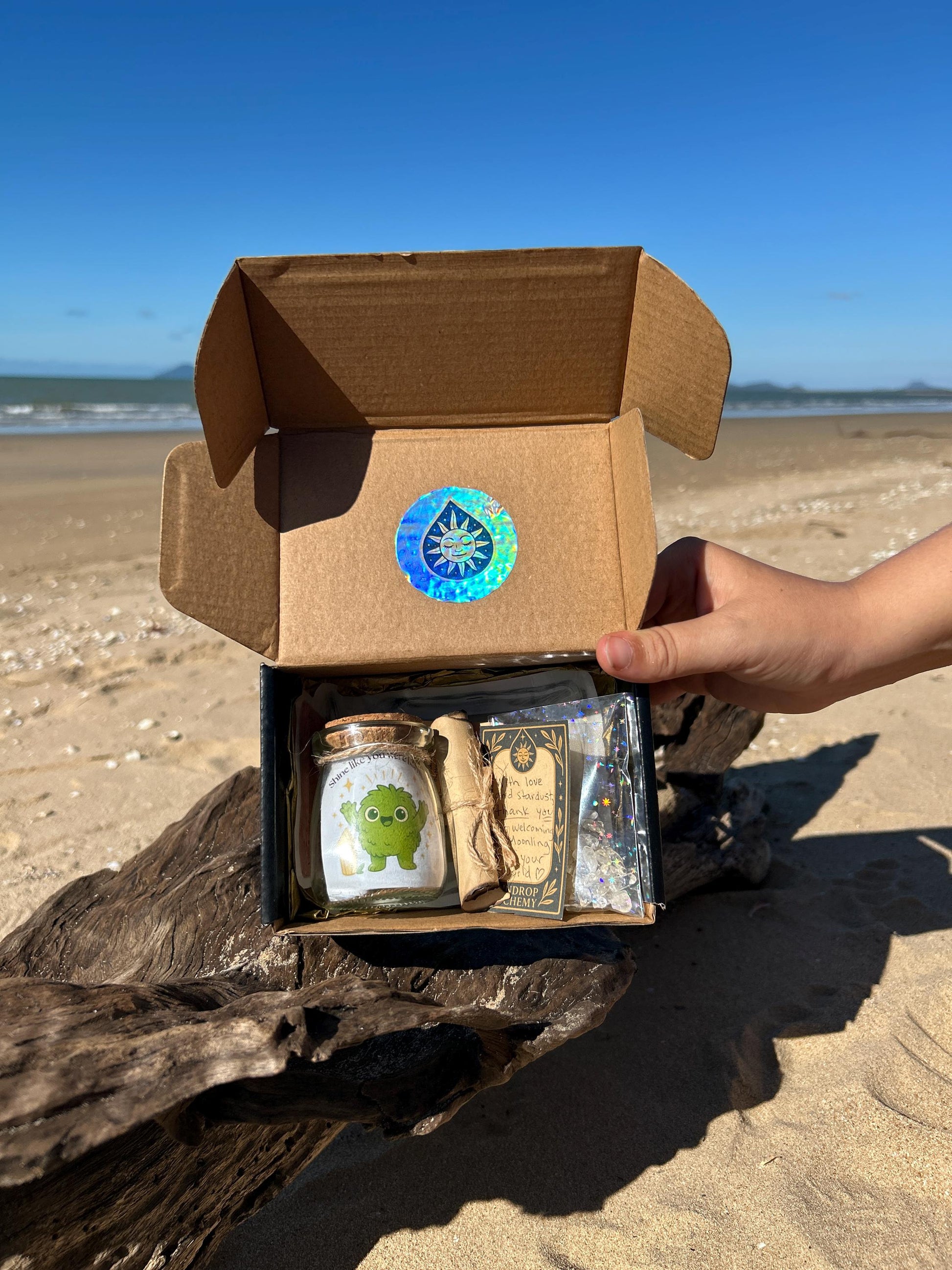Golden Moonling Box with contents on a beach
