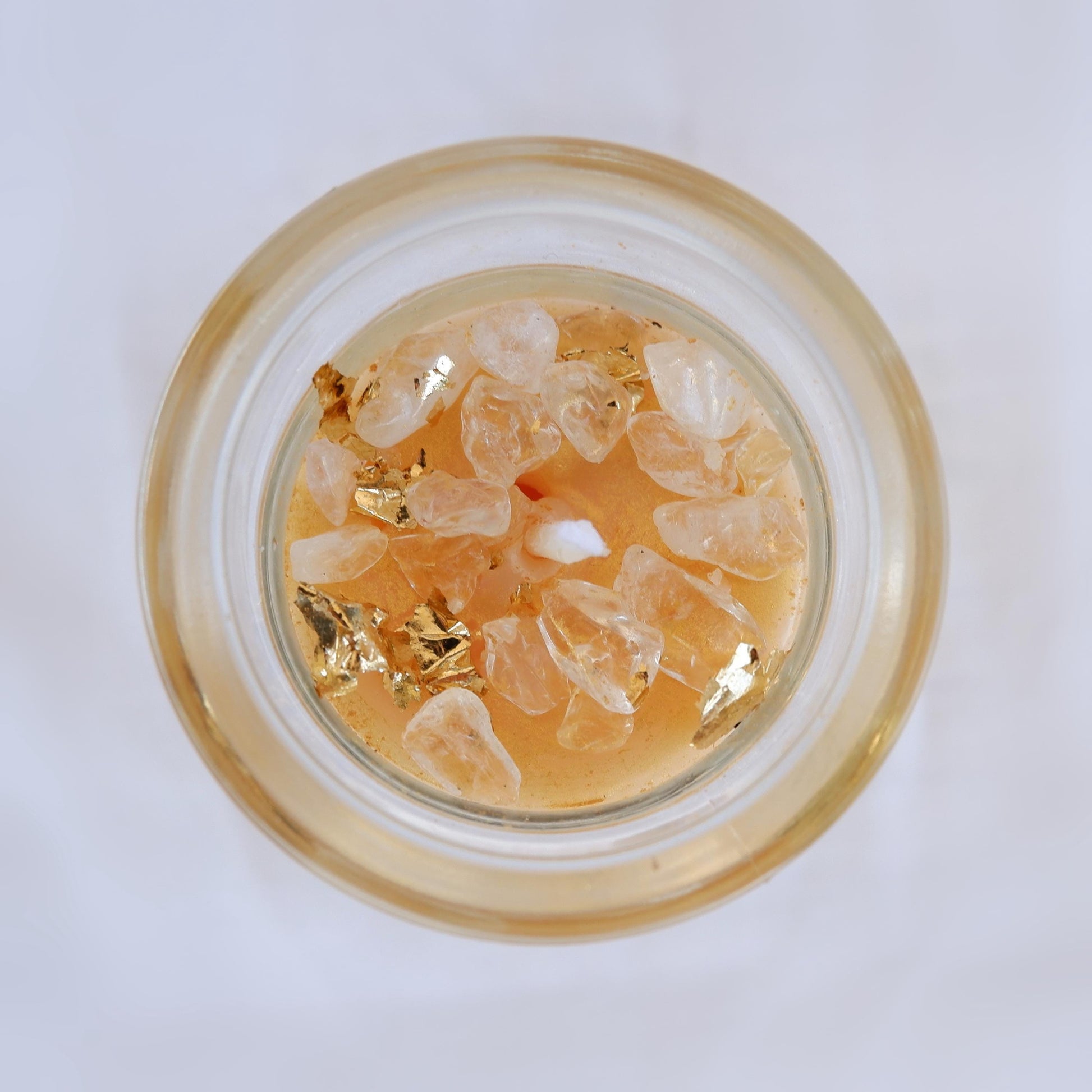 Small glass container with gold and clear decorative elements on a white background