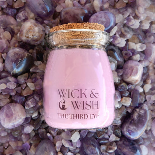 The Third Eye candle in a glass jar with cork lid on purple amethyst stones, featuring 'Wick & Wish' branding.