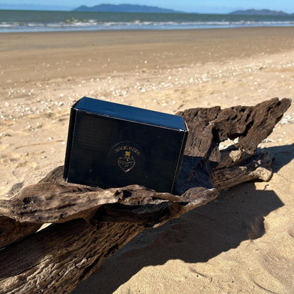 Black box with a magic inside logo on a piece of driftwood on a beach