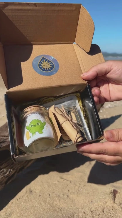 Golden Moonling packaging showcased on the beach with a glass jar, sticker, scroll shown